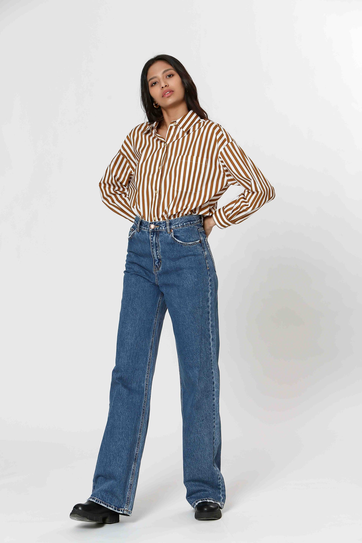 This Striped Blouse by The Korner adds a touch of fun to your wardrobe with its white and camel stripes. Versatile enough for layering or wearing on its own, this button-down blouse will make you stand out in style.