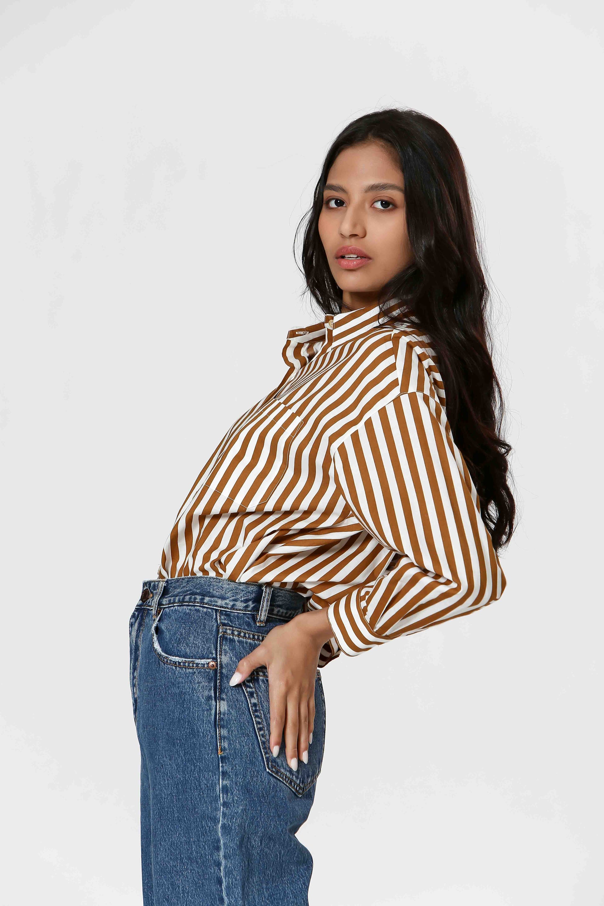 This Striped Blouse by The Korner adds a touch of fun to your wardrobe with its white and camel stripes. Versatile enough for layering or wearing on its own, this button-down blouse will make you stand out in style.