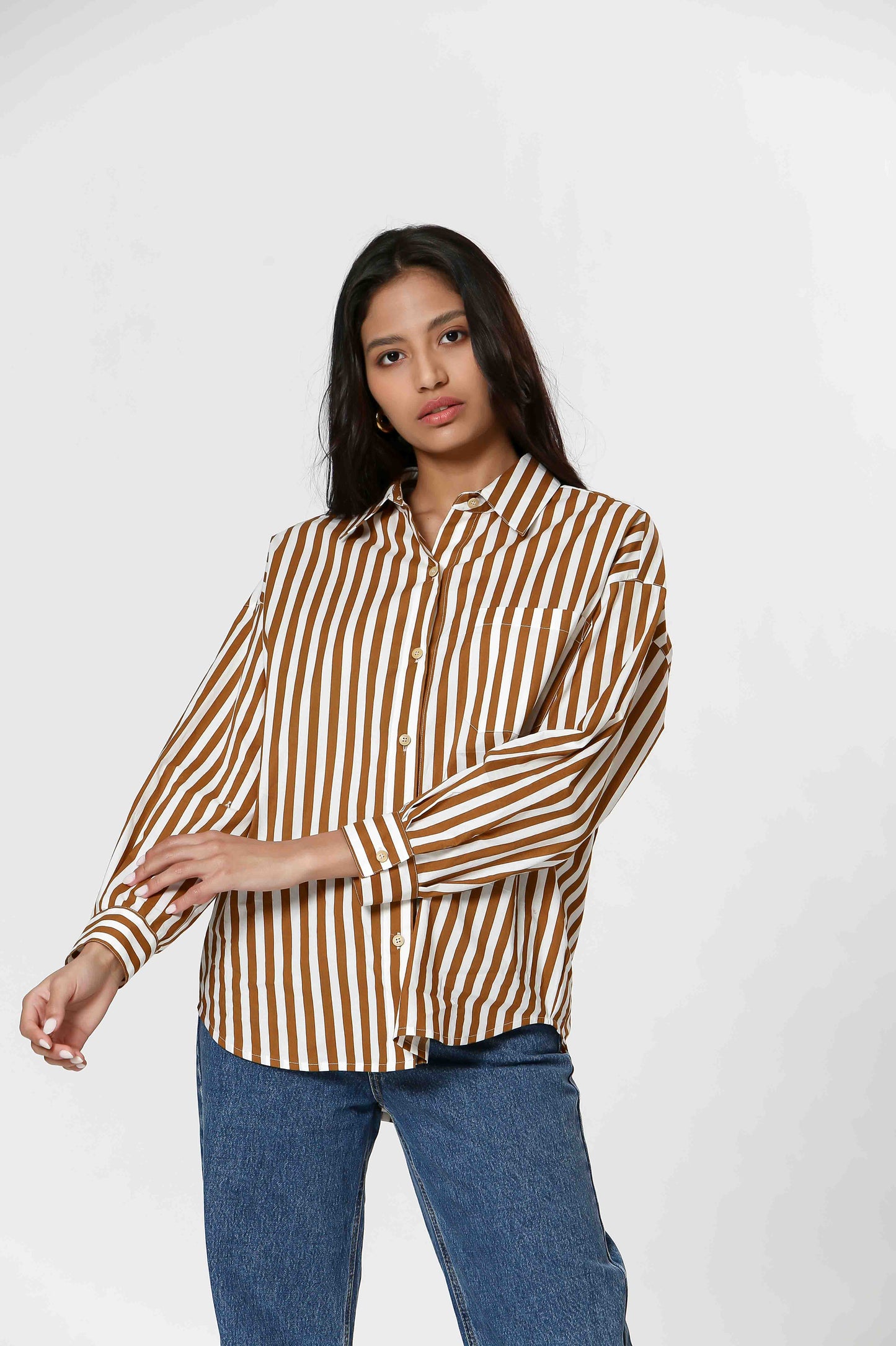 This Striped Blouse by The Korner adds a touch of fun to your wardrobe with its white and camel stripes. Versatile enough for layering or wearing on its own, this button-down blouse will make you stand out in style.