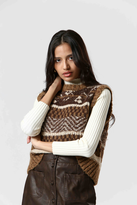 Stay cozy and stylish with The Korner's Check Sweater Vest! In shades of brown and cream, this vest features a playful check pattern with stripes, chevrons, and fairisle designs. 