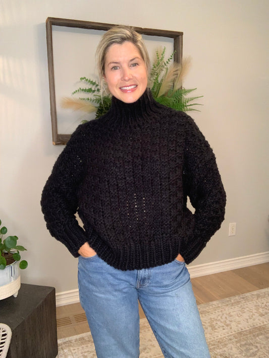 Get cozy and look chic with our Chunky Black Sweater from The Korner. This knit sweater in black boasts a basketweave design and a trendy mock neck for extra warmth. 