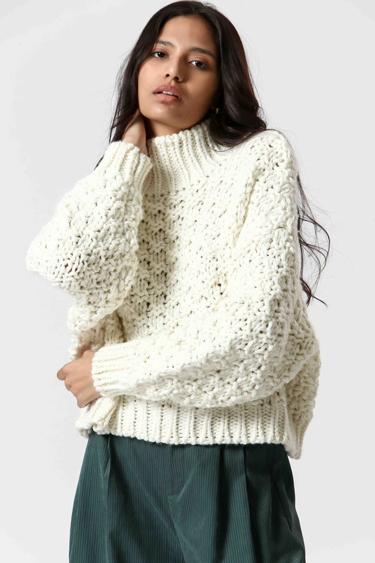 Stay cozy and stylish in our Chunky Cream Sweater by The Korner. This cream knit sweater features a basketweave pattern and a chic mock neck for added warmth. 