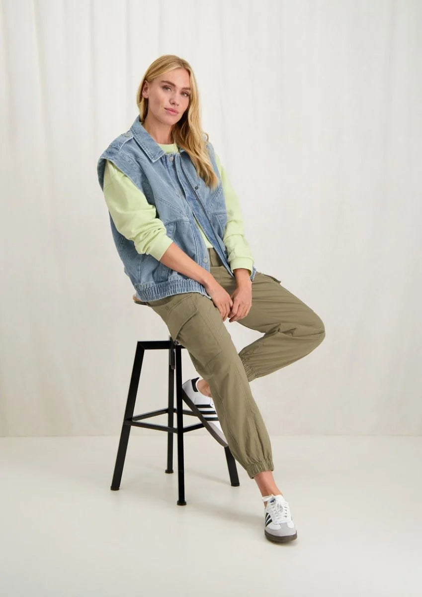 Elevate your casual style with our Paige Sleeveless Denim Jacket by Circle of Trust, crafted from durable non-stretch denim in a timeless vintage blue hue. Boasting a relaxed silhouette, this vest features an adjustable elastic waistband for a customized fit, complemented by a convenient zipper closure adorned with classic press studs. Retro style to give your outfit a pop!