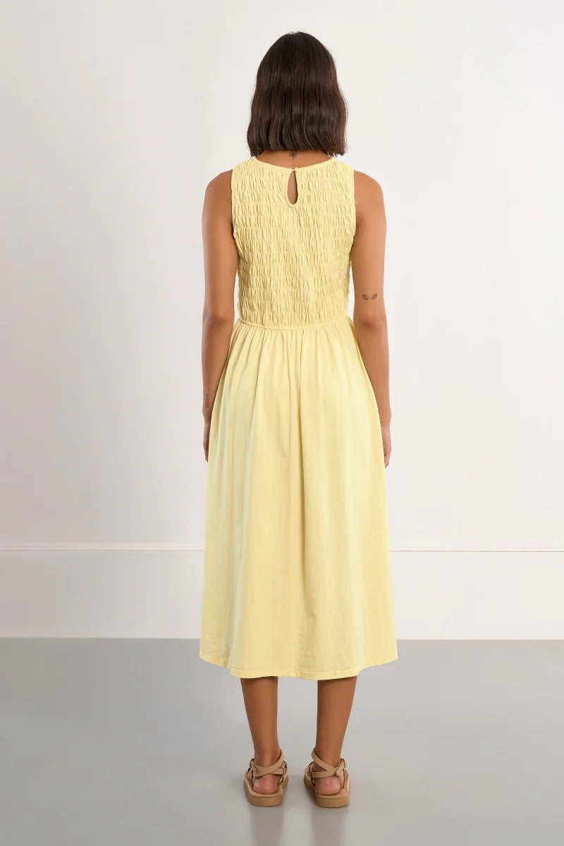 Woman wearing a yellow dress on a plain background