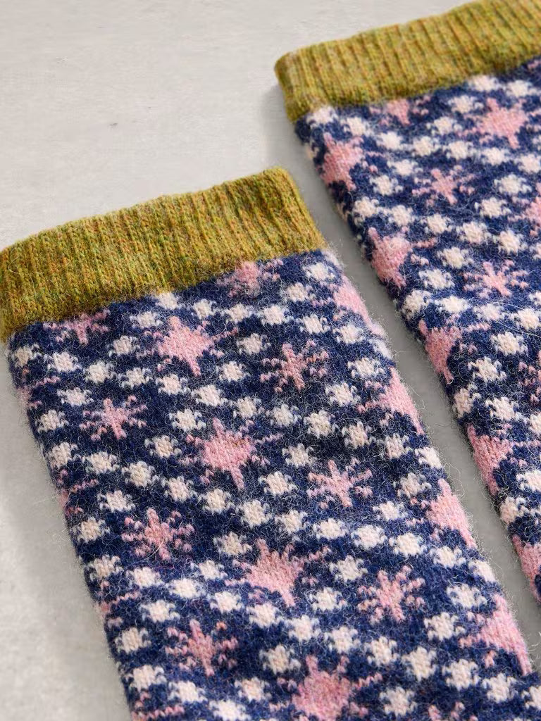 Pair of patterned socks with green cuffs on a light gray background