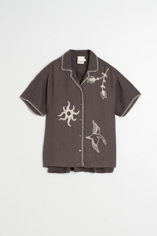 Dark gray shirt with white embroidery on a light gray background