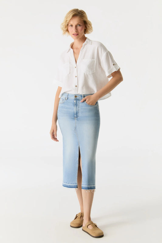 Woman wearing a white shirt and light blue denim skirt on a white background
