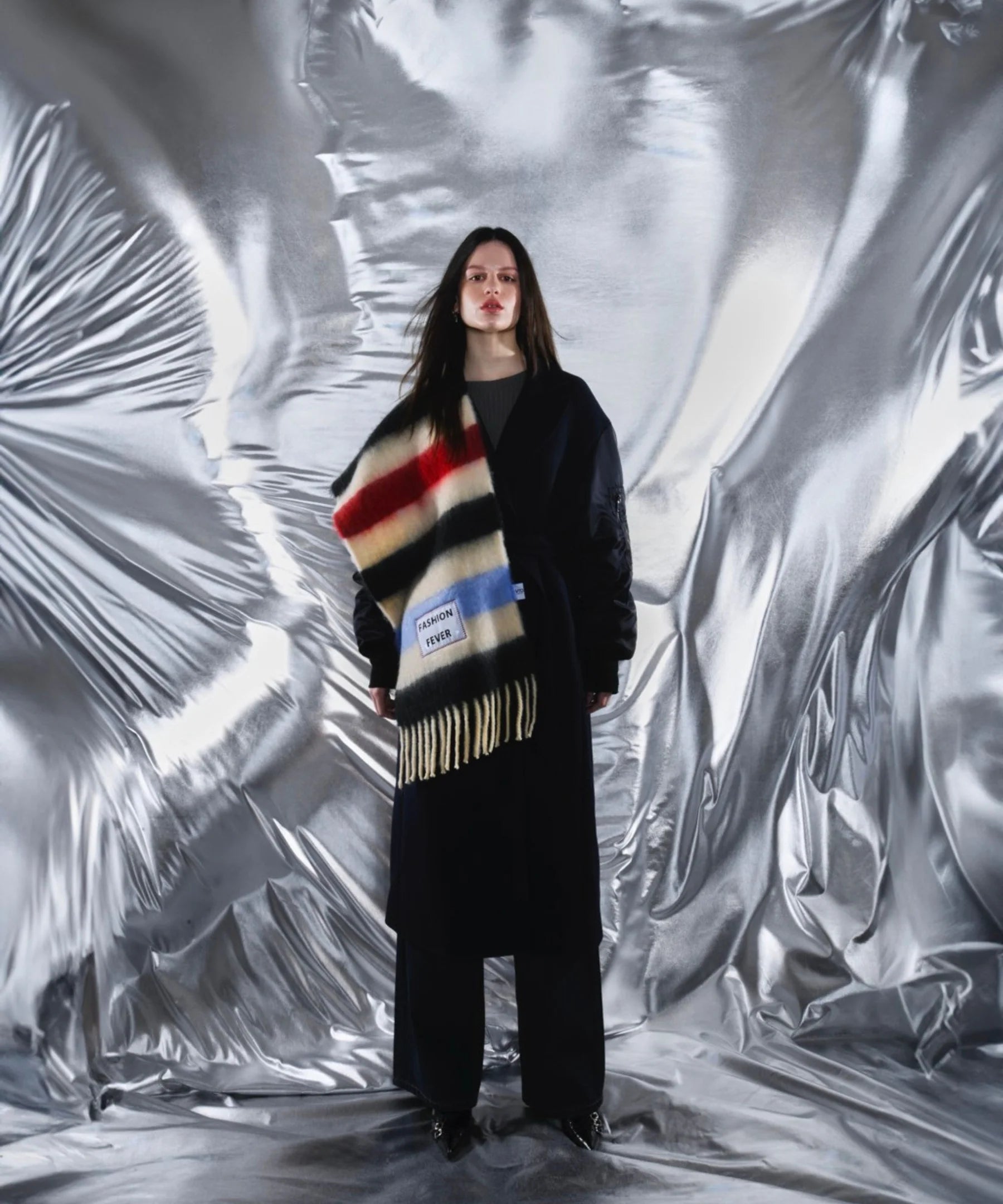 Person wearing a colorful striped sweater with a patterned background