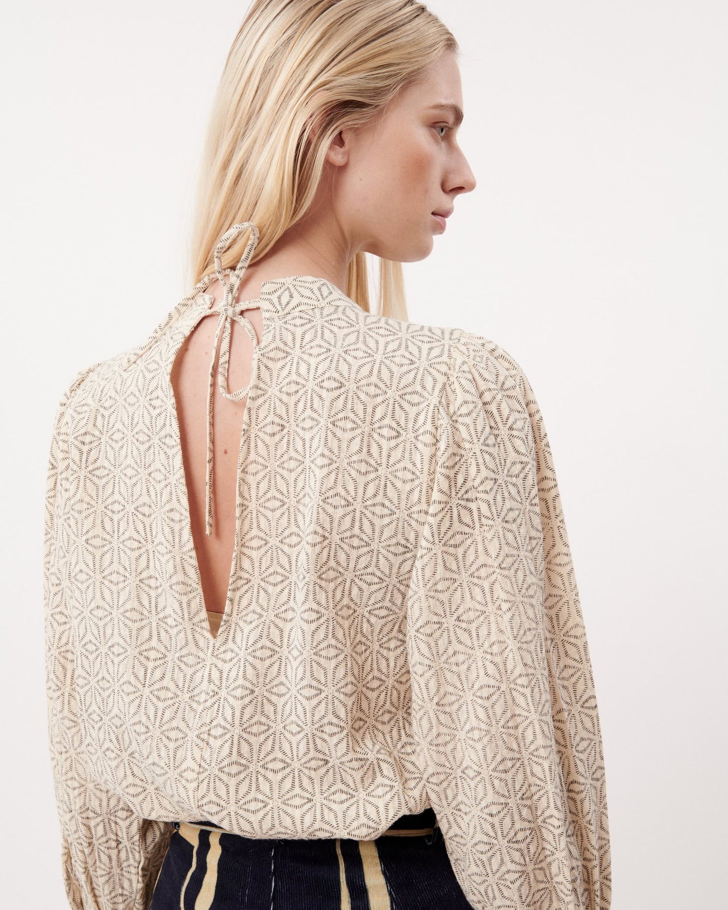 This FRNCH high neck cream coloured cropped blouse ties at the back of the neck and has a v shaped cut out.  It has a beautiful embroidered geometric pattern in a black thread throughout.  lemon cyprus boutique