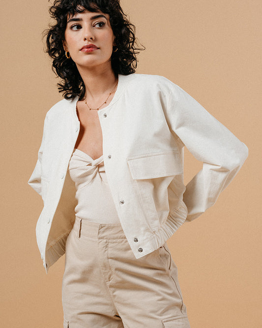 Introducing the silhouette: Bomber jackets have evolved into a cult favorite and an essential in every woman's wardrobe, especially this season. Explore our feminine and elegant take on the classic bomber: MEGANE, crafted from 100% cotton, ensuring versatility across all seasons in it's warm whate ecru colour. This cropped bomber is an absolute standout, effortlessly pairing with both pumps and sneakers alike.
