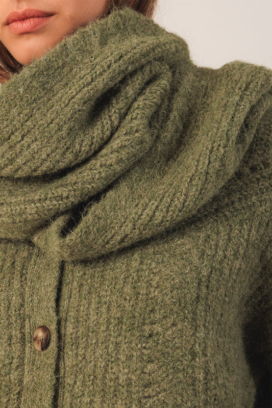 Close-up of a green knitted cardigan with a scarf