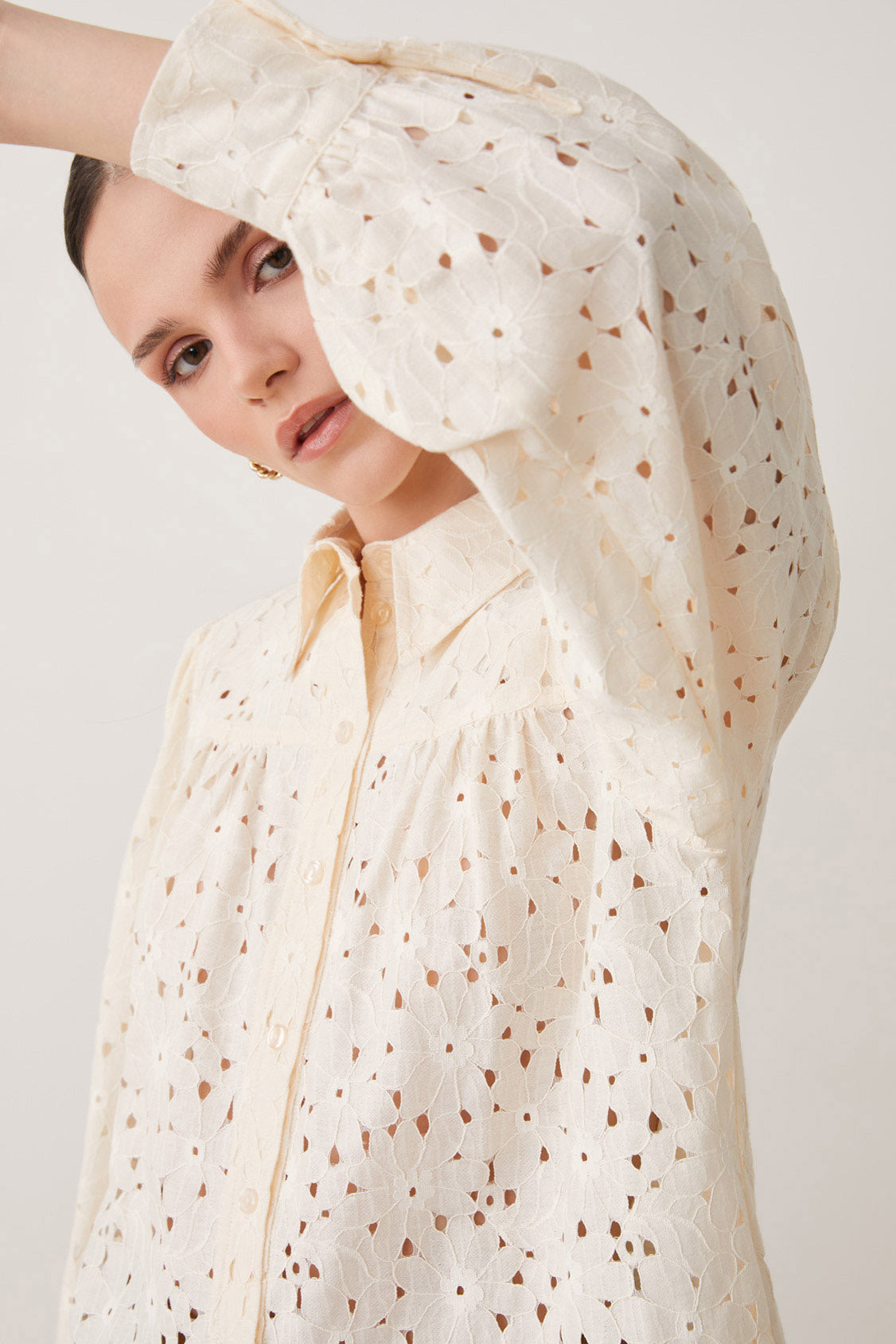 Elevate your style with this playful Guipure Lace Blouse by Suncoo from Paris. Featuring long sleeves and a buttoned closure, this blouse boasts a shirt collar for a sophisticated touch. The delicate guipure lace adds a touch of femininity to this vanilla coloured top.