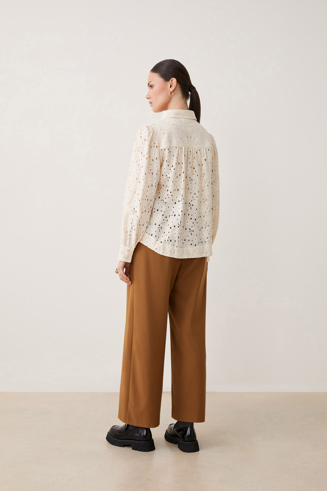 Elevate your style with this playful Guipure Lace Blouse by Suncoo from Paris. Featuring long sleeves and a buttoned closure, this blouse boasts a shirt collar for a sophisticated touch. The delicate guipure lace adds a touch of femininity to this vanilla coloured top.