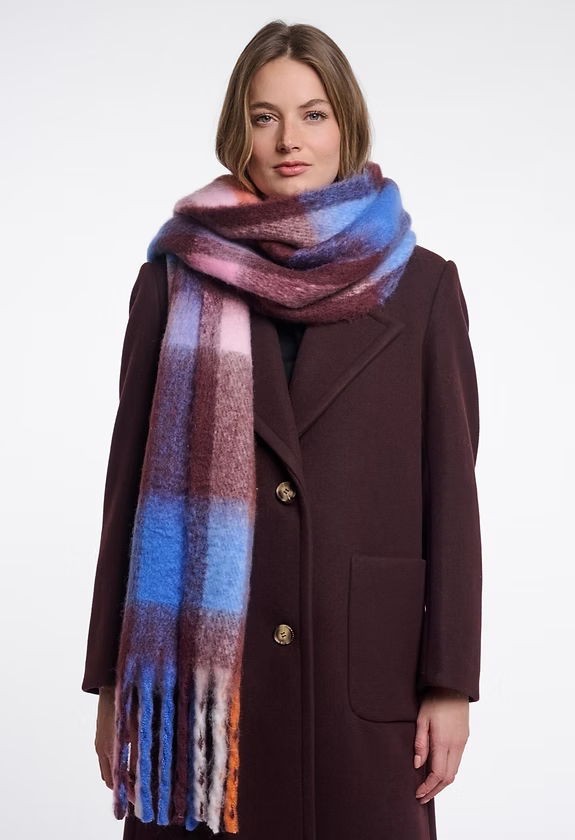 Woman wearing the Rino & Pelle Hibbe oversized check scarf in burgundy, blue and pink with fringe ends, styled with a burgundy wool coat