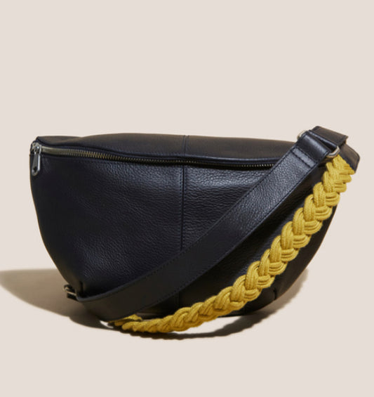 The versatile navy Sebby leather sling bag by White Stuff comes with two straps — one leather, one plaited in contrasting chartreuse green. There's nothing handier than going hands-free. Crafted from high-quality leather, the Sebby Leather Sling offers both style and convenience with its two straps. Enjoy the freedom of going hands-free while staying stylish with this versatile bag. Wear it crossbody for a chic casual look or wear it with the plaited arm strap for a dressier look.