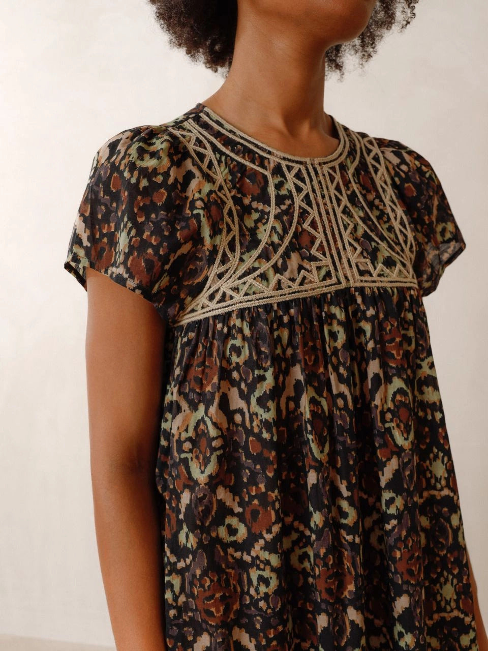 The Chevron Embroidered dress by Indi &amp; Cold has chevron-detail embroidery, ethnic print and lightweight fabric with a very nice drape. It features a round neck that closes with a button, a fitted shoulder and short sleeves. The perfect balance of unique and classic.