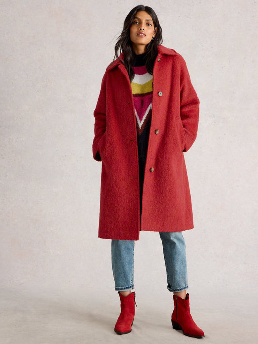 Person wearing a red coat with a neutral background