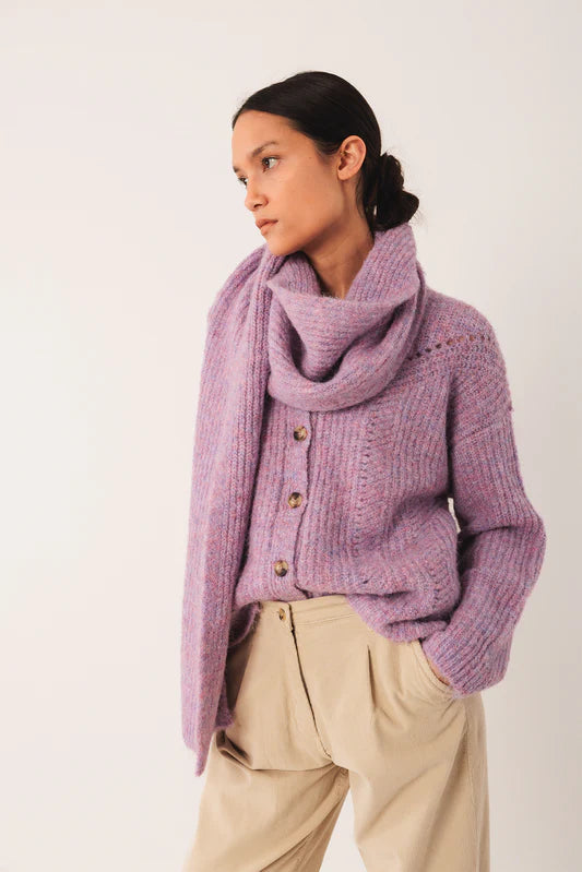 Woman wearing a purple sweater and scarf on a white background