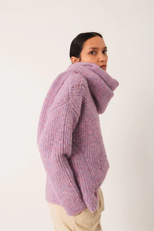 Person wearing a purple knitted sweater on a white background