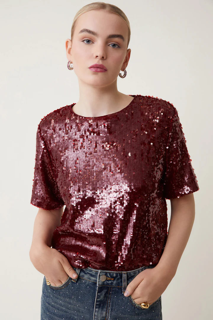 Get ready to sparkle and shine in the Louise Top from Suncoo! With short sleeves and a round collar, this burgundy sequin top adds a touch of glamour to any outfit. Perfect for a night out or a special occasion, the Louise Top will make you stand out from the crowd.