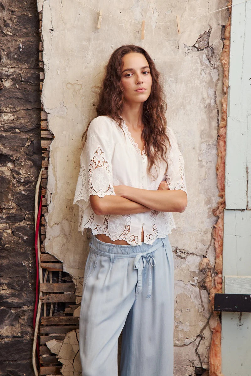 Woman standing against a textured wall with arms crossed