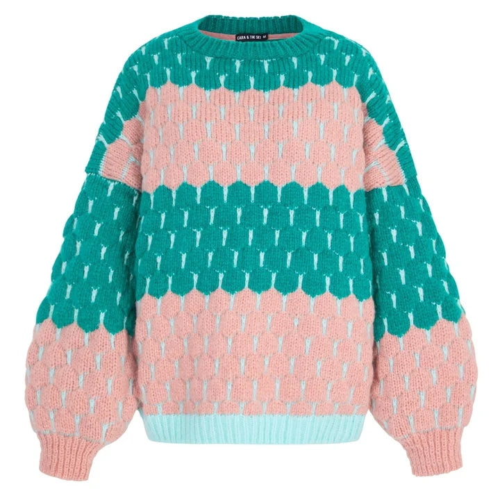 Woman wearing the Marissa green and pink bubble stitch sweater with balloon sleeves and jeans