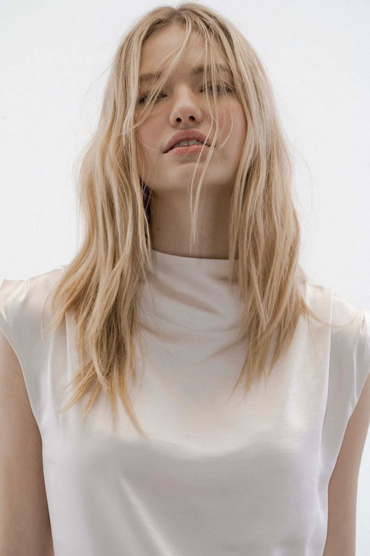 Stunning Bahia satin pearl blouse by Melissa Nepton with a beautiful draped mock neck, keyhole-button opening behing, cap sleeves with two petite pleats at the shoulder, a seam down the back, and finishes off at the hip. lemon cypruse boutique