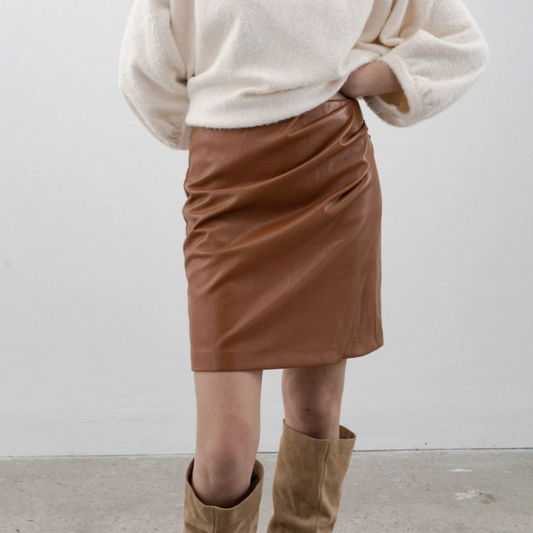 This luxurious Kori skirt from Melissa Nepton is made from a high-quality faux vegan leather that feels remarkably similar to lambskin. Perfect for the fall season, the rich cinnamon colour adds spectacular dimension. The wrap design features a hidden back zipper and five decorative covered buttons, ensuring you never need to worry about wardrobe mishaps. It pairs perfectly with pullovers, knee-high or ankle boots, or even sneakers! lemon cyprus boutique