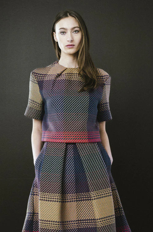 Woman wearing a patterned dress against a black background