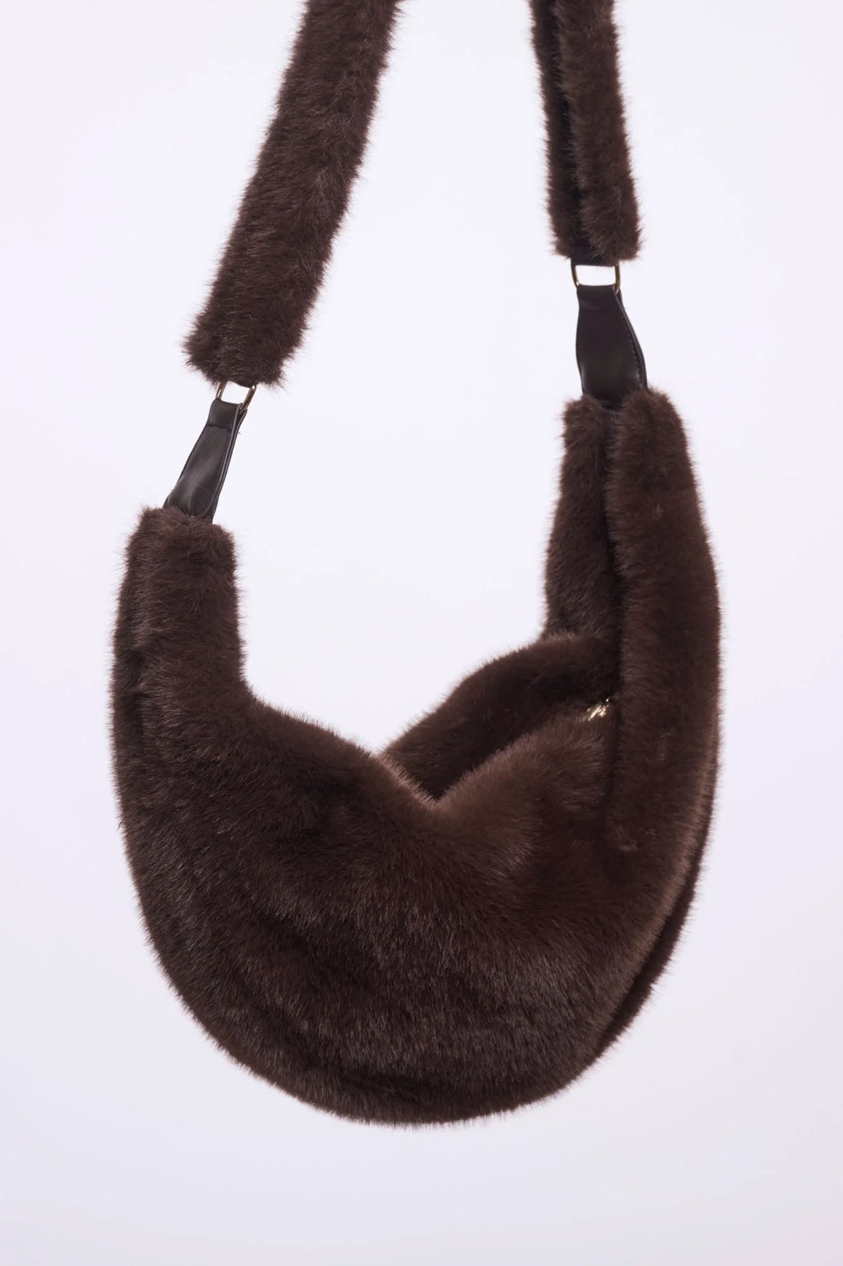Rino & Pelle Nayla chocolate brown faux fur crescent crossbody bag worn across the body over a black wool coat