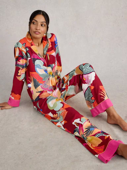 Woman wearing a colorful floral pajama set on a neutral background
