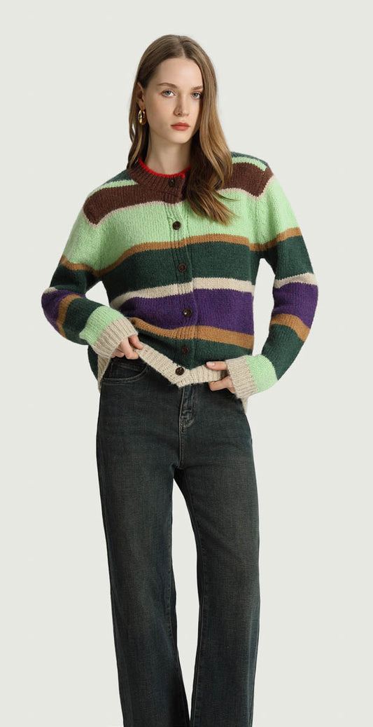 Woman wearing the Ninon striped colorblock knit cardigan in green, purple and brown with dark wide-leg jeans