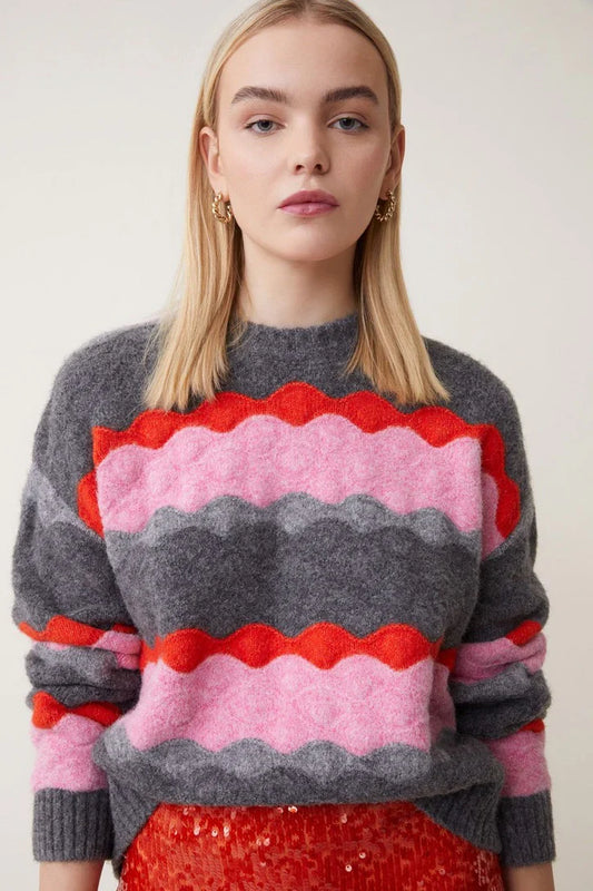 Get ready to snuggle up in the Pananyo wavy stripe sweater from Suncoo! This soft and stylish sweater has a round neck, long sleeves with ribbed finishes, and a relaxed fit. The pink and red wavy stripe design on grey adds a playful touch to this cozy piece in a super-soft mix blend fabric.