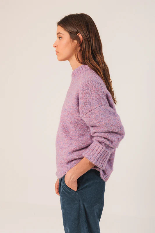 Woman wearing a purple sweater against a white background