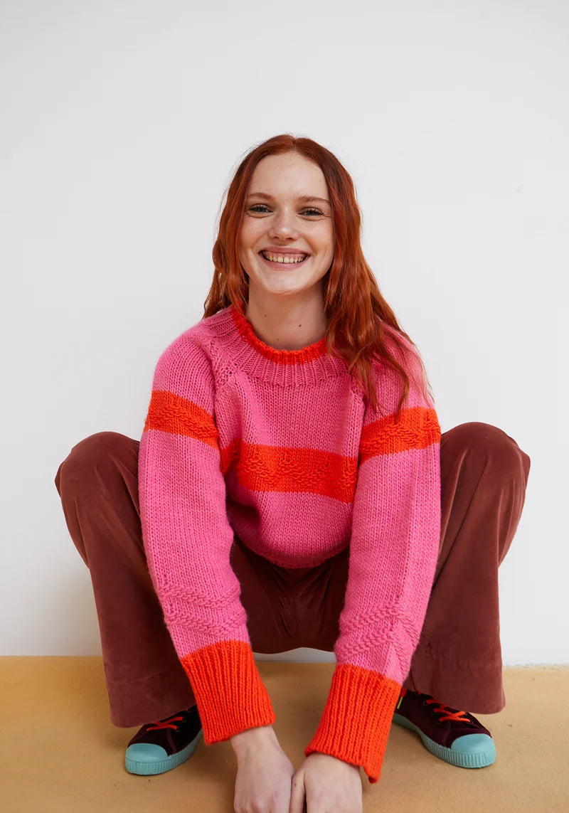 Woman wearing pink and orange Carmelo Pink Candy Sweater by Dr Bloom, front view
