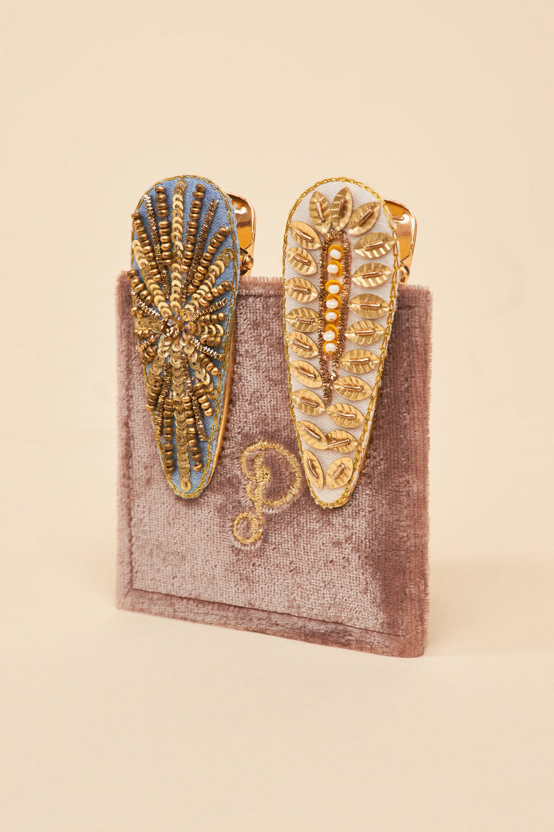 Discover the elegant and charming combination of wheatgrass and starburst in exquisite hair clips by Powder UK. Handcrafted in India, these clips feature a sunrise-inspired design with a touch of vintage flair. Delicately presented  with a velvet card, they make for a timeless and thoughtful gift or a special self-indulgence.