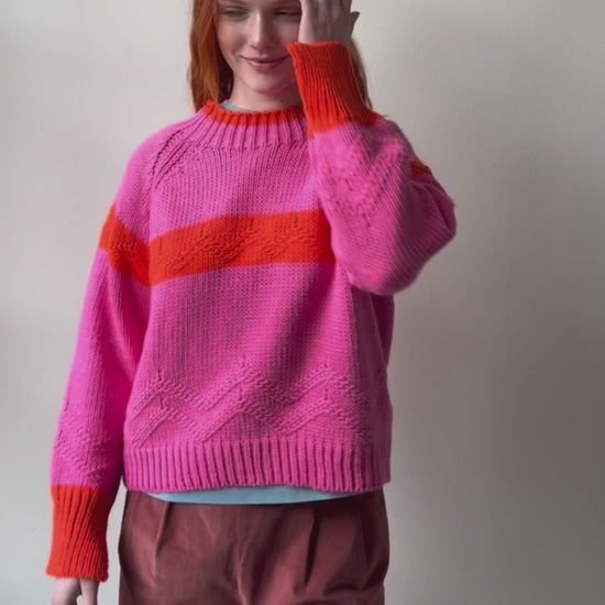 Woman wearing pink and orange Carmelo Pink Candy Sweater by Dr Bloom, front view
