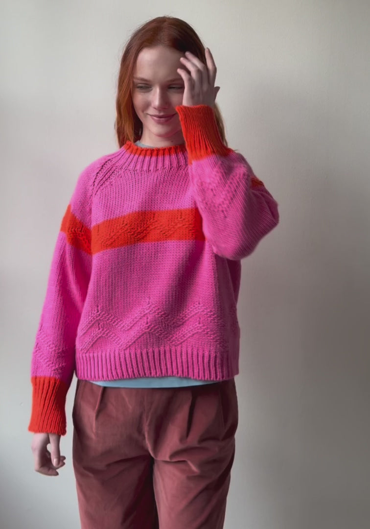 Woman wearing pink and orange Carmelo Pink Candy Sweater by Dr Bloom, front view