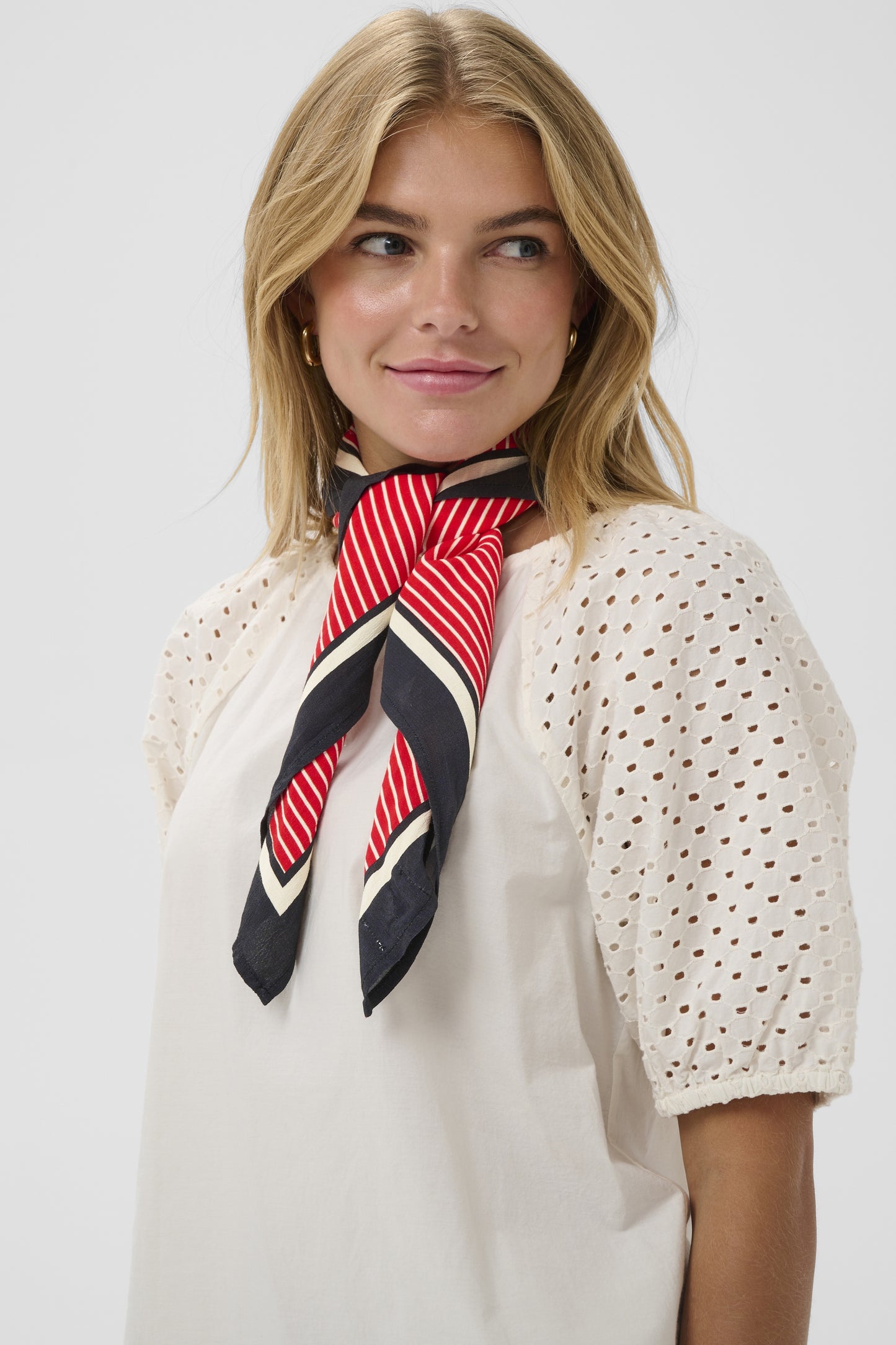 Woman wearing a red and black striped scarf on a white background