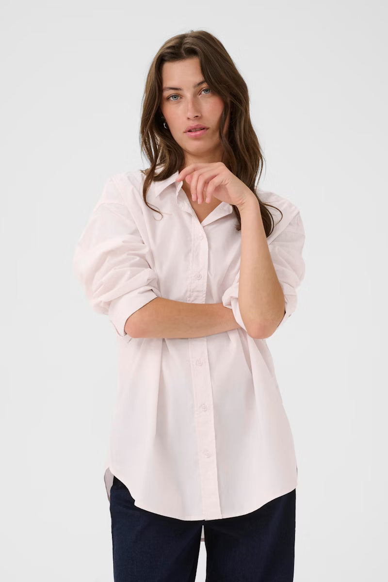 Woman wearing a light pink shirt on a white background