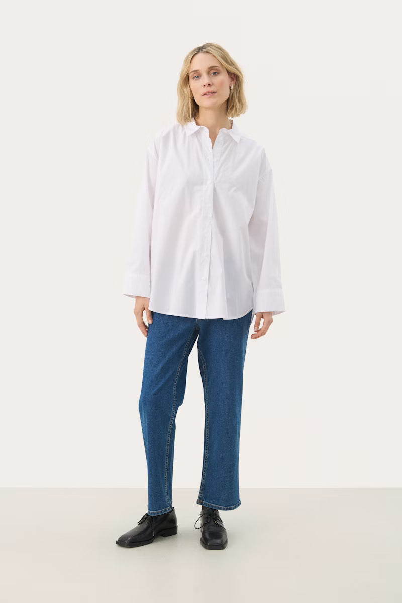 Woman wearing a white shirt and blue jeans on a white background