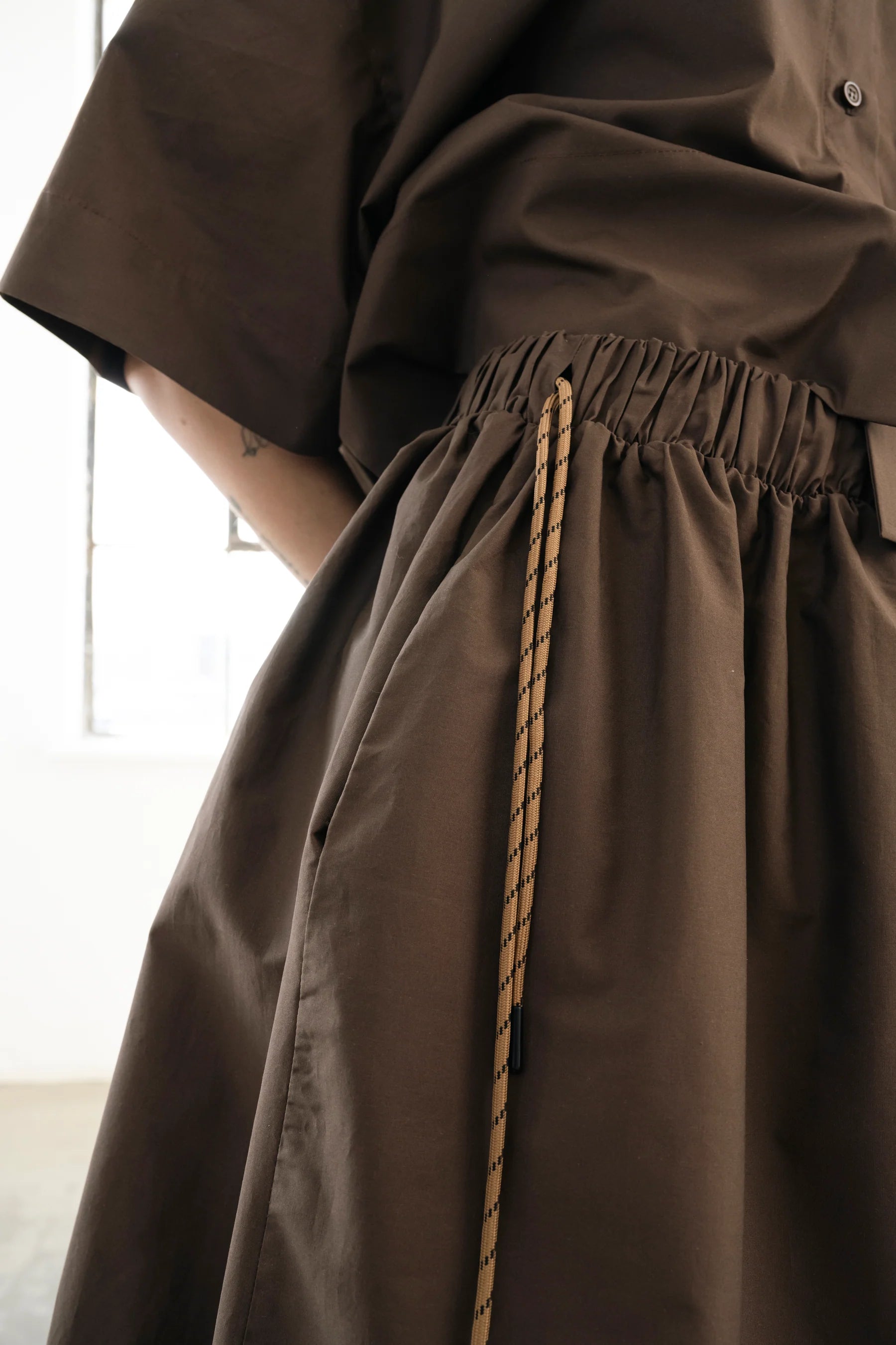 Brown voluminous cotton midi skirt with side cords and pockets by Bodybag by Jude