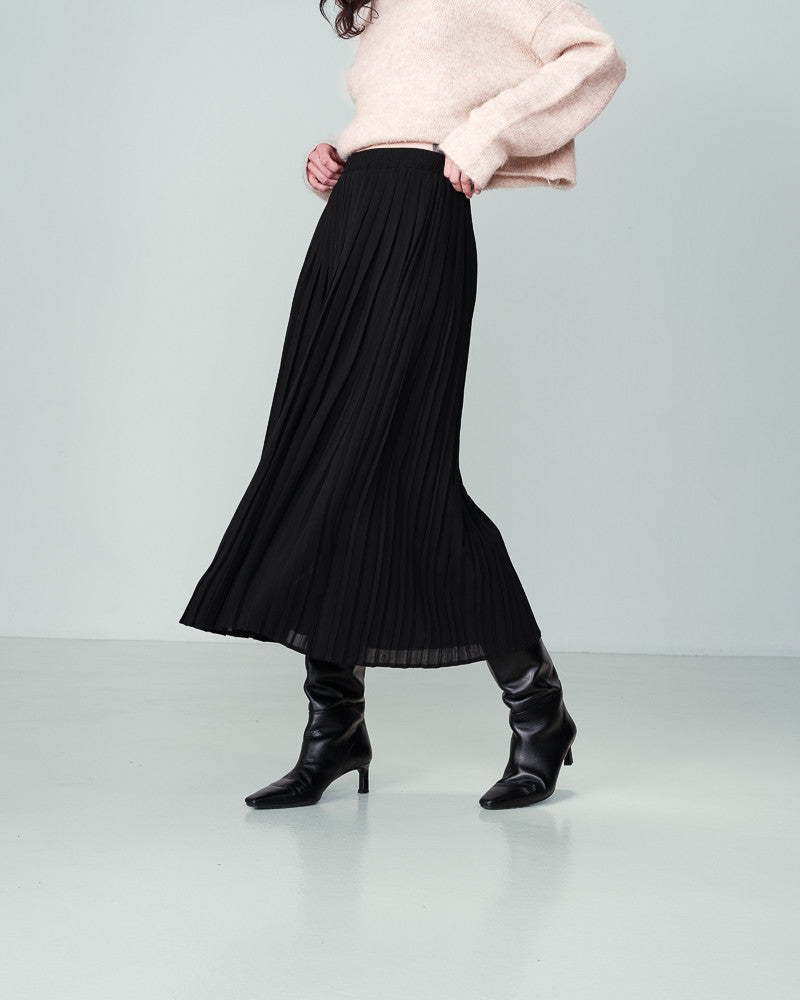  The NINON long skirt by Grace &amp; Mila exudes comfort with its elasticated waist and voluminous design. Its full length and lining make it a staple for every season. This black pleated skirt is both elegant and refined, effortlessly creating a graceful and ethereal silhouette. lemon cyprus boutique