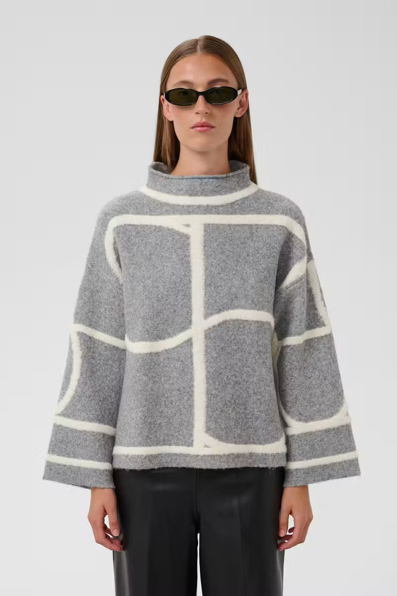 Woman wearing grey oversized sweater with ivory colour-block seaming by Soaked in Luxury, paired with black leather pants