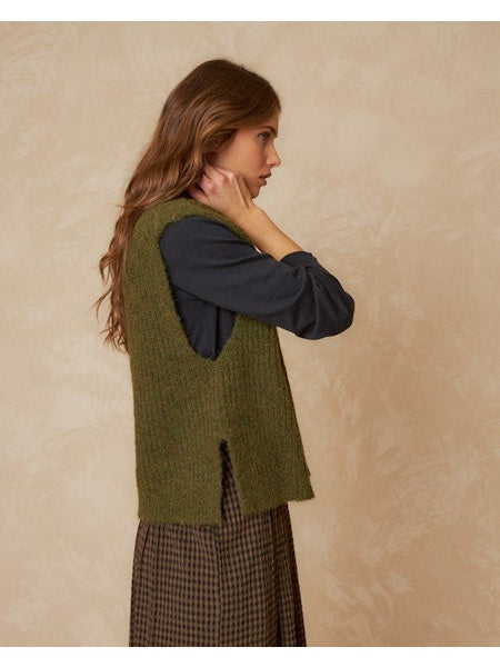 Elevate your style with this knitted vest by Indi &amp; Cold crafted from recycled fibers, showcasing a unique square pattern and comfortable fit. The beutiful knaki green colour is perfect for wearing with a tee or blouse, it's elevated by its broad armholes and playful, spacious, and suare design!