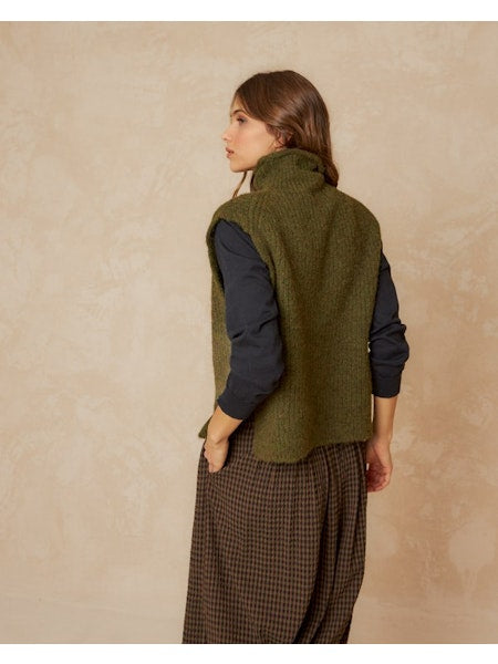 Elevate your style with this knitted vest by Indi &amp; Cold crafted from recycled fibers, showcasing a unique square pattern and comfortable fit. The beutiful knaki green colour is perfect for wearing with a tee or blouse, it's elevated by its broad armholes and playful, spacious, and suare design!