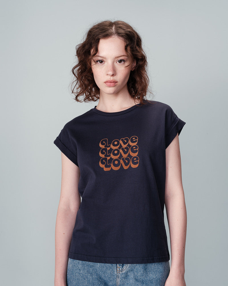 "Ninalou", the tee from Grace &amp; Mila, is a marine short-sleeve with caramel coloured velvet lettering that spells out "LOVE". Featuring a round neckline, short sleeves with lapels, and a flattering straight cut, this tee is perfect for all body types.