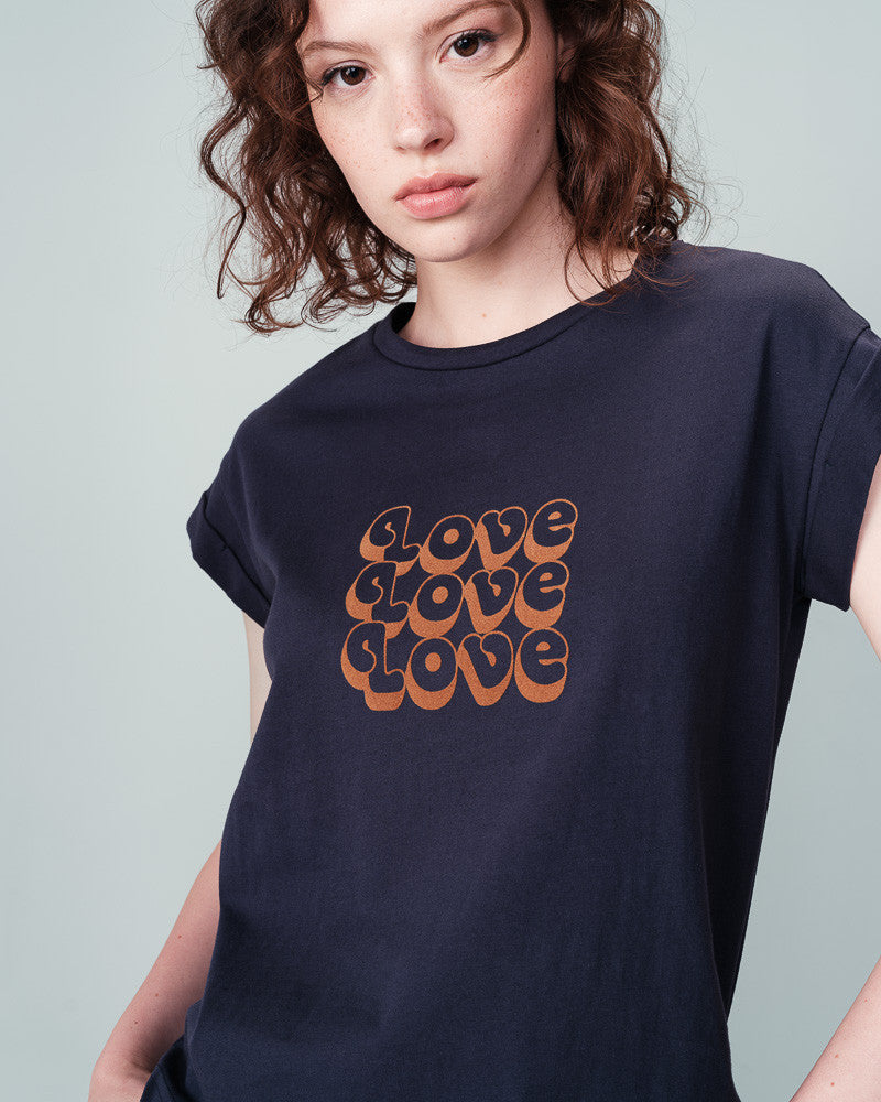 "Ninalou", the tee from Grace &amp; Mila, is a marine short-sleeve with caramel coloured velvet lettering that spells out "LOVE". Featuring a round neckline, short sleeves with lapels, and a flattering straight cut, this tee is perfect for all body types.