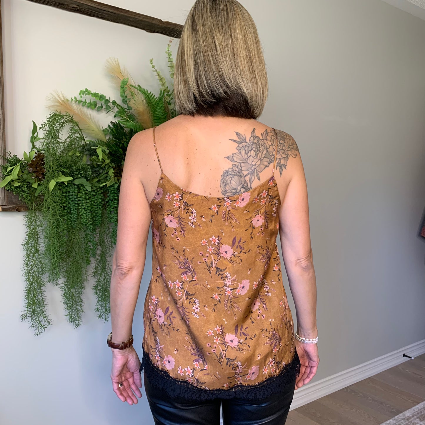 This Floral Camisole by the Korner presents a straight cut with black lace trimming around the hemline. An eye-catching, soft floral pattern in purple and pinks is set against a deep, velvety cinnamon hue, providing a luxuriously matte silk like finish. lemon cyprus boutique