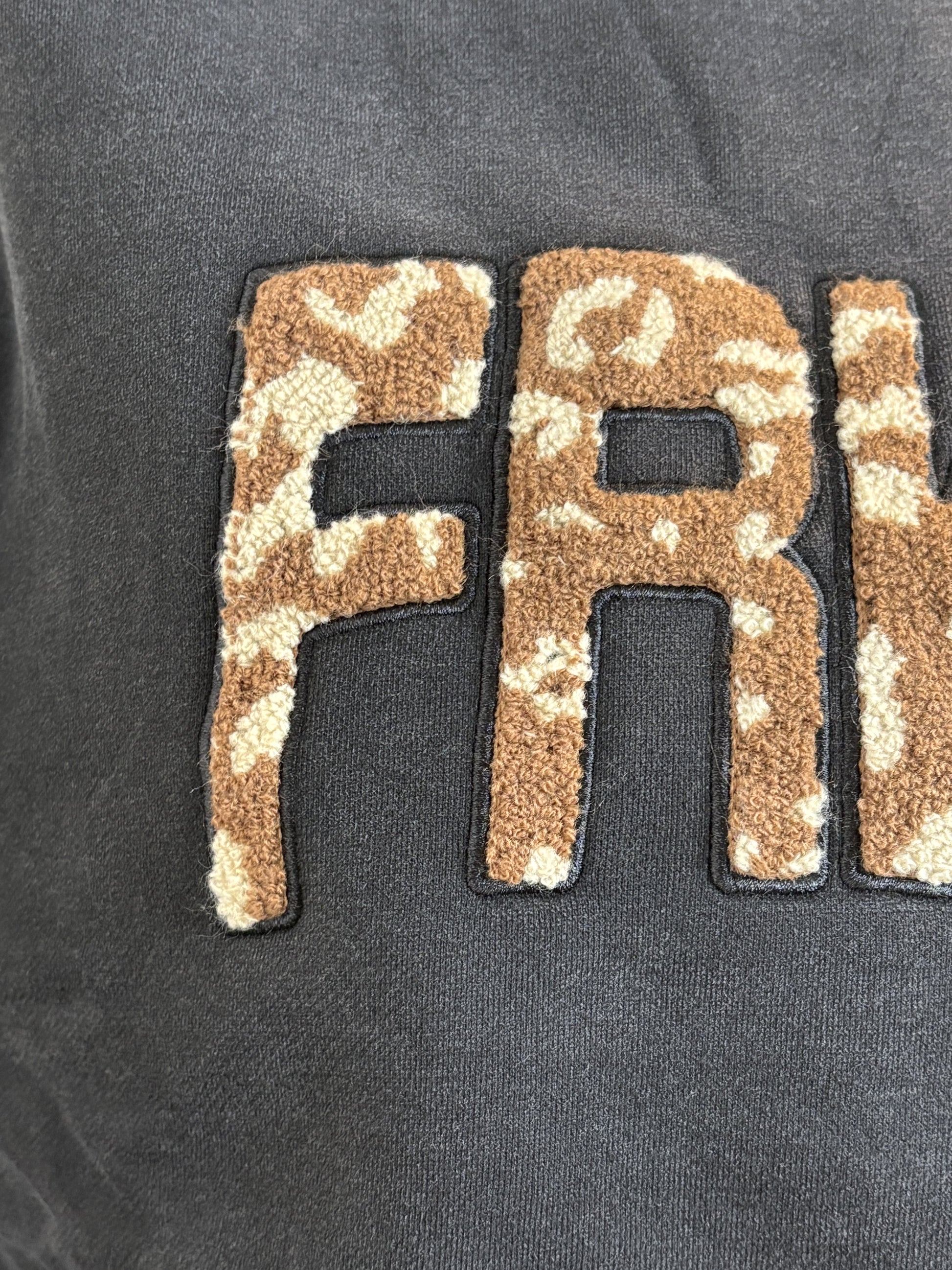 Textured 'FR' patch on a dark background